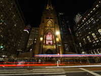 Traffic and pedestrians make their way along Broadway past Trinity Church in New York, N.Y., on December 12, 2024. (