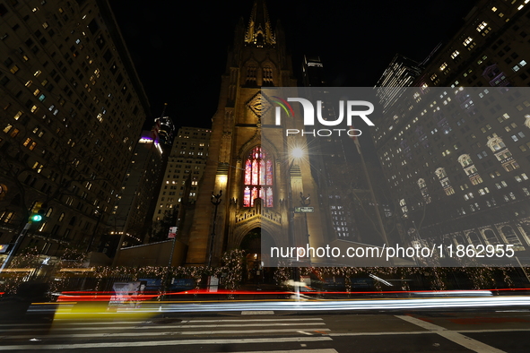 Traffic and pedestrians make their way along Broadway past Trinity Church in New York, N.Y., on December 12, 2024. 