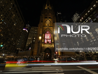 Traffic and pedestrians make their way along Broadway past Trinity Church in New York, N.Y., on December 12, 2024. (