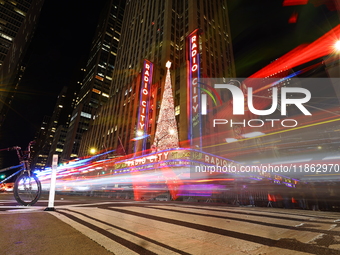 Car and foot traffic goes by Radio City Music Hall in New York, N.Y., on December 12, 2024. The photo is taken as a long exposure. (