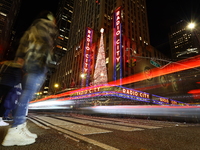 Car and foot traffic goes by Radio City Music Hall in New York, N.Y., on December 12, 2024. The photo is taken as a long exposure. (