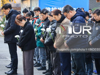 People stand in silence in front of the memorial for the victims of the Nanjing Massacre by Japanese invaders at the Zhengjue Temple in Nanj...