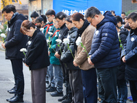 People stand in silence in front of the memorial for the victims of the Nanjing Massacre by Japanese invaders at the Zhengjue Temple in Nanj...