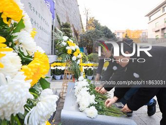 People present flowers to the memorial for the victims of the Nanjing Massacre by Japanese invaders at Zhengjue Temple in Nanjing, East Chin...