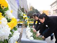 People present flowers to the memorial for the victims of the Nanjing Massacre by Japanese invaders at Zhengjue Temple in Nanjing, East Chin...