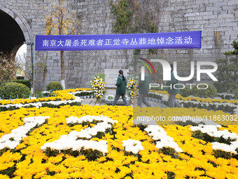 Students salute in front of the memorial for the victims of the Nanjing Massacre by Japanese invaders at Zhengjue Temple in Nanjing, Jiangsu...