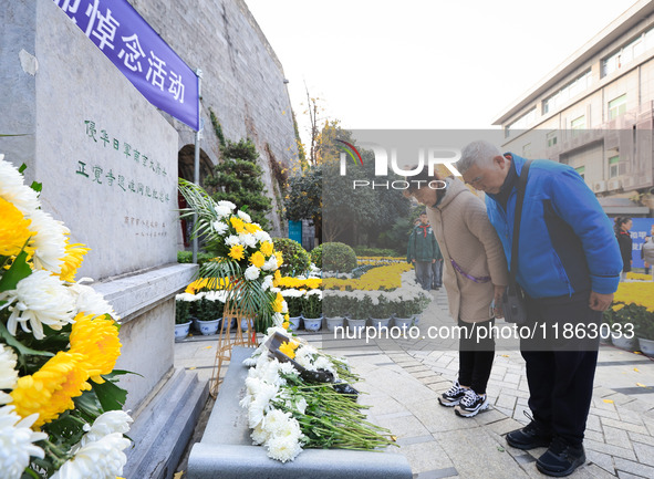 People pay their respects in front of the memorial monument for the victims of the Nanjing Massacre by Japanese invaders in Nanjing, East Ch...