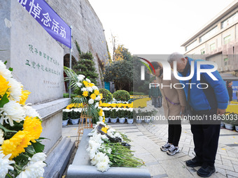 People pay their respects in front of the memorial monument for the victims of the Nanjing Massacre by Japanese invaders in Nanjing, East Ch...