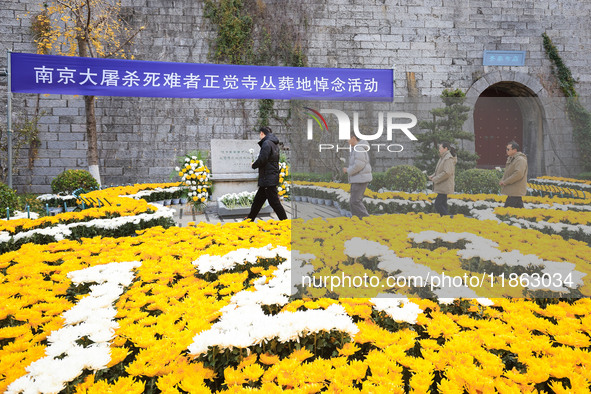 People present flowers to the memorial for the victims of the Nanjing Massacre by Japanese invaders at Zhengjue Temple in Nanjing, East Chin...