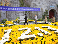 People present flowers to the memorial for the victims of the Nanjing Massacre by Japanese invaders at Zhengjue Temple in Nanjing, East Chin...