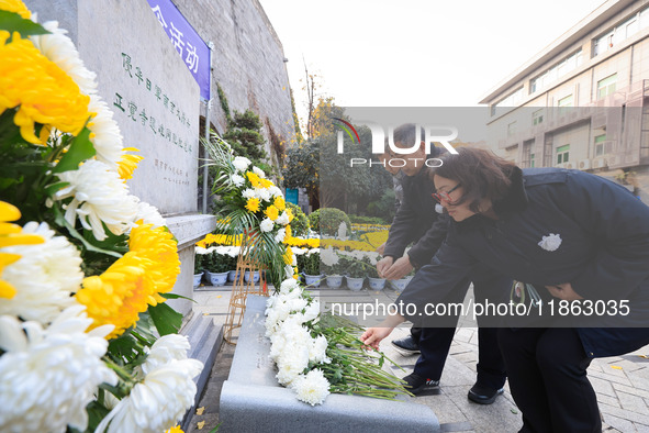 People present flowers to the memorial for the victims of the Nanjing Massacre by Japanese invaders at Zhengjue Temple in Nanjing, East Chin...