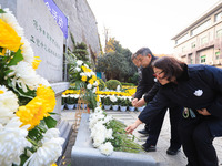 People present flowers to the memorial for the victims of the Nanjing Massacre by Japanese invaders at Zhengjue Temple in Nanjing, East Chin...