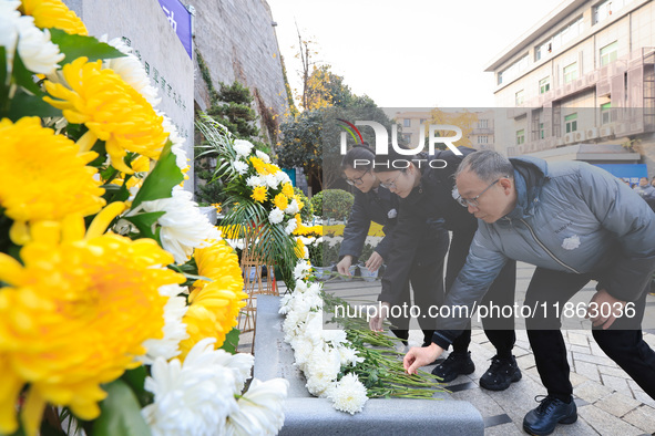 People present flowers to the memorial for the victims of the Nanjing Massacre by Japanese invaders at Zhengjue Temple in Nanjing, East Chin...