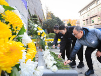 People present flowers to the memorial for the victims of the Nanjing Massacre by Japanese invaders at Zhengjue Temple in Nanjing, East Chin...