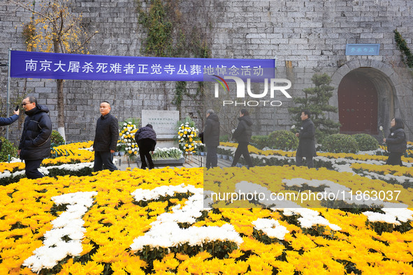 People present flowers to the memorial for the victims of the Nanjing Massacre by Japanese invaders at Zhengjue Temple in Nanjing, East Chin...