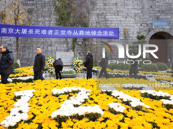 People present flowers to the memorial for the victims of the Nanjing Massacre by Japanese invaders at Zhengjue Temple in Nanjing, East Chin...