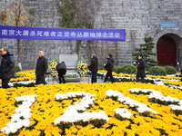 People present flowers to the memorial for the victims of the Nanjing Massacre by Japanese invaders at Zhengjue Temple in Nanjing, East Chin...