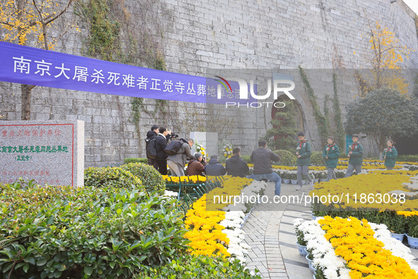 People present flowers to the memorial for the victims of the Nanjing Massacre by Japanese invaders at Zhengjue Temple in Nanjing, East Chin...