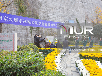 People present flowers to the memorial for the victims of the Nanjing Massacre by Japanese invaders at Zhengjue Temple in Nanjing, East Chin...