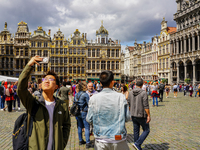 An Asian tourist takes a selfie with his smartphone, capturing the historic charm of the Grand Place in Brussels, Belgium, on July 30, 2023....