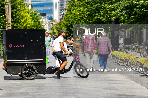 A man rides a cargo bike through a pedestrian zone in Brussels, Belgium, on July 30, 2023. The cargo bike, branded Dockr, represents a susta...