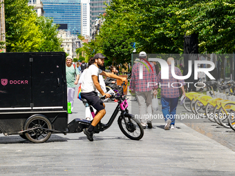 A man rides a cargo bike through a pedestrian zone in Brussels, Belgium, on July 30, 2023. The cargo bike, branded Dockr, represents a susta...