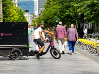 A man rides a cargo bike through a pedestrian zone in Brussels, Belgium, on July 30, 2023. The cargo bike, branded Dockr, represents a susta...