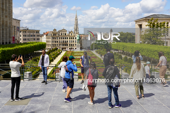 Tourists gather at the Mont des Arts in Brussels, Belgium, on July 30, 2023, capturing photographs of the landscaped gardens, the statue of...