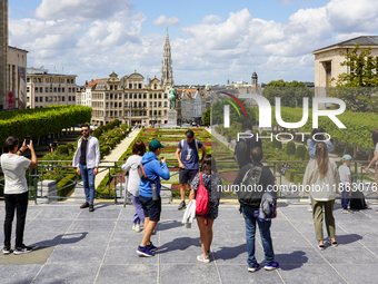 Tourists gather at the Mont des Arts in Brussels, Belgium, on July 30, 2023, capturing photographs of the landscaped gardens, the statue of...