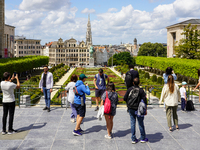 Tourists gather at the Mont des Arts in Brussels, Belgium, on July 30, 2023, capturing photographs of the landscaped gardens, the statue of...