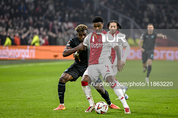 Lazio midfielder Fisayo Dele-Bashiru and AFC Ajax Amsterdam defender Jorrel Hato play during the match between Ajax and Lazio at the Johan C...