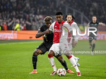 Lazio midfielder Fisayo Dele-Bashiru and AFC Ajax Amsterdam defender Jorrel Hato play during the match between Ajax and Lazio at the Johan C...