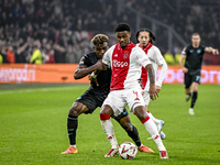 Lazio midfielder Fisayo Dele-Bashiru and AFC Ajax Amsterdam defender Jorrel Hato play during the match between Ajax and Lazio at the Johan C...