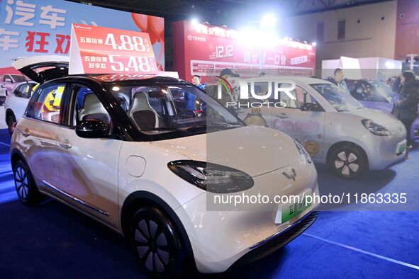 Exhibitors present subsidies and preferential promotion measures at the 16th Shandong International Auto Show 2024 in Qingdao, China, on Dec...