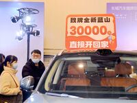 Exhibitors present subsidies and preferential promotion measures at the 16th Shandong International Auto Show 2024 in Qingdao, China, on Dec...