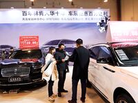 Exhibitors present subsidies and preferential promotion measures at the 16th Shandong International Auto Show 2024 in Qingdao, China, on Dec...