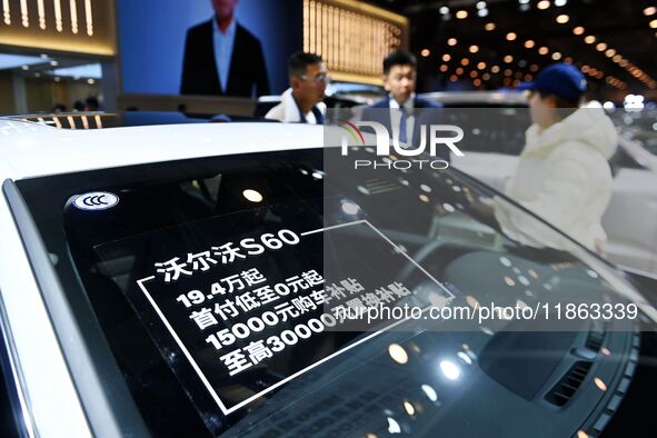 Exhibitors present subsidies and preferential promotion measures at the 16th Shandong International Auto Show 2024 in Qingdao, China, on Dec...