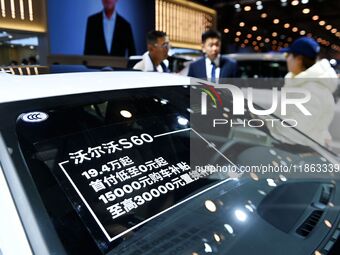 Exhibitors present subsidies and preferential promotion measures at the 16th Shandong International Auto Show 2024 in Qingdao, China, on Dec...