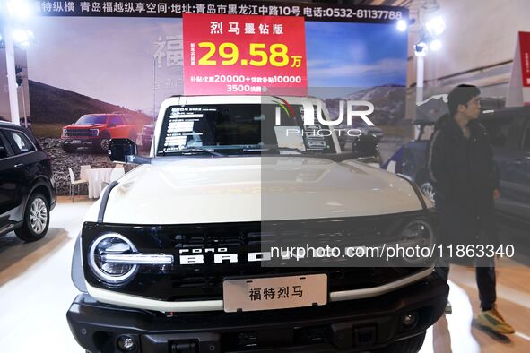 Exhibitors present subsidies and preferential promotion measures at the 16th Shandong International Auto Show 2024 in Qingdao, China, on Dec...