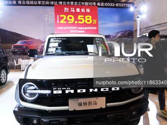 Exhibitors present subsidies and preferential promotion measures at the 16th Shandong International Auto Show 2024 in Qingdao, China, on Dec...