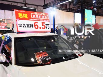 Exhibitors present subsidies and preferential promotion measures at the 16th Shandong International Auto Show 2024 in Qingdao, China, on Dec...