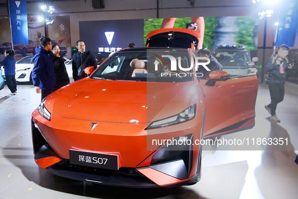 People view cars at the 16th Shandong International Auto Show in Qingdao, China, on December 13, 2024. 