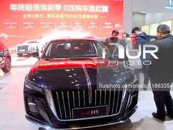 People view cars at the 16th Shandong International Auto Show in Qingdao, China, on December 13, 2024. (