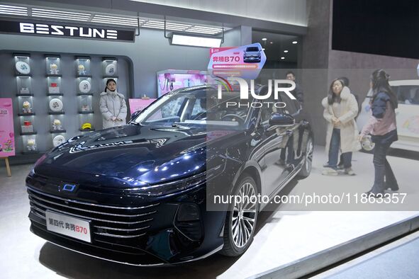 People view cars at the 16th Shandong International Auto Show in Qingdao, China, on December 13, 2024. 