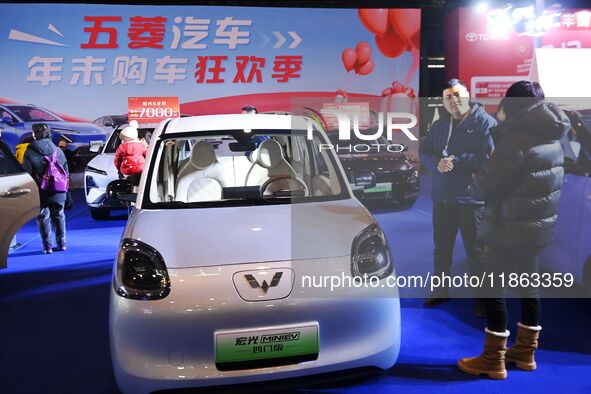 People view cars at the 16th Shandong International Auto Show in Qingdao, China, on December 13, 2024. 