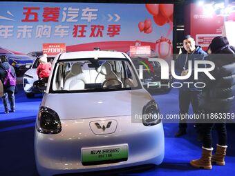 People view cars at the 16th Shandong International Auto Show in Qingdao, China, on December 13, 2024. (