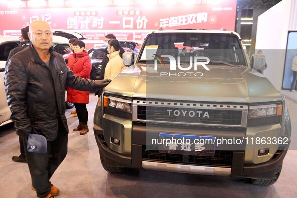 People view cars at the 16th Shandong International Auto Show in Qingdao, China, on December 13, 2024. 