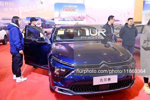 People view cars at the 16th Shandong International Auto Show in Qingdao, China, on December 13, 2024. 