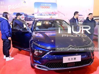 People view cars at the 16th Shandong International Auto Show in Qingdao, China, on December 13, 2024. (