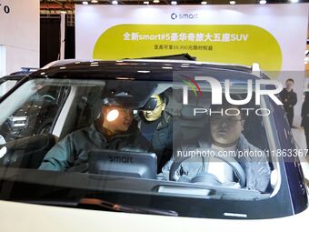 People view cars at the 16th Shandong International Auto Show in Qingdao, China, on December 13, 2024. (